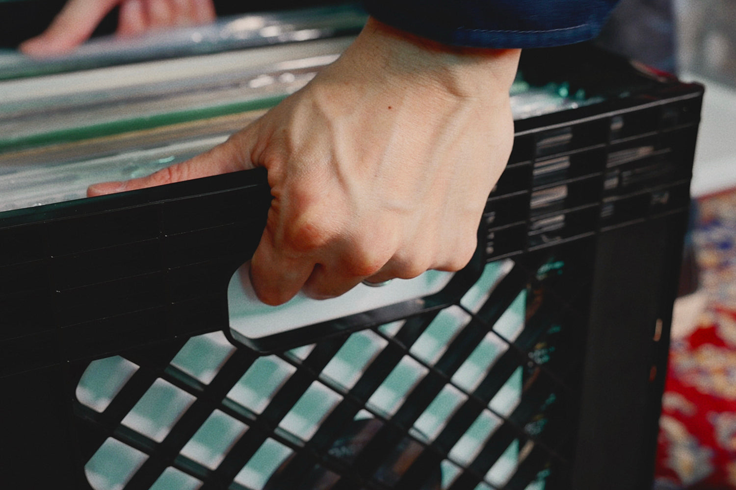 Close-up of the ergonomic handle on a Thumb & Wonders foldable crate, highlighting sturdy PP construction for carrying heavy vinyl record collections.