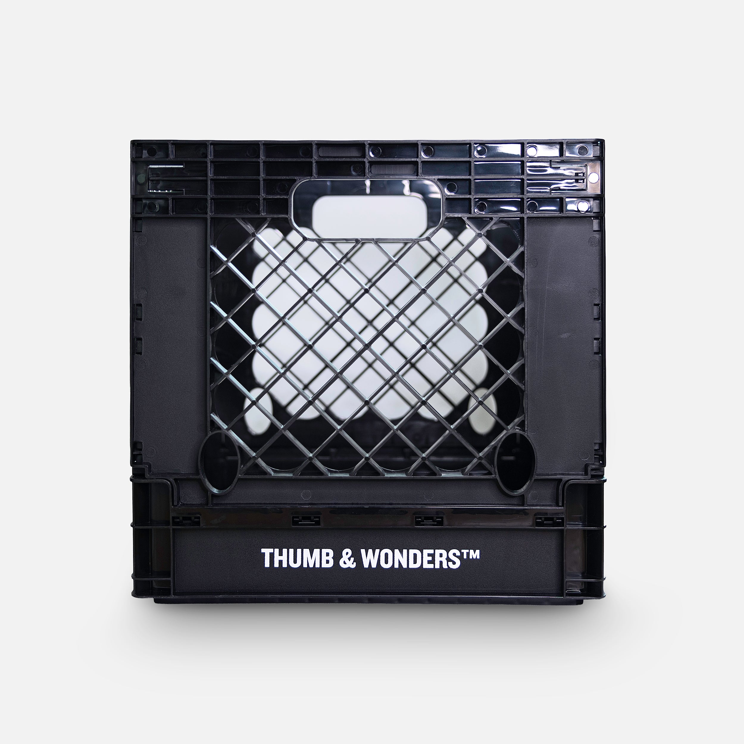 Front view of the Thumb & Wonders black record crate featuring the white brand logo and a clean, symmetrical grid aesthetic for modern living.