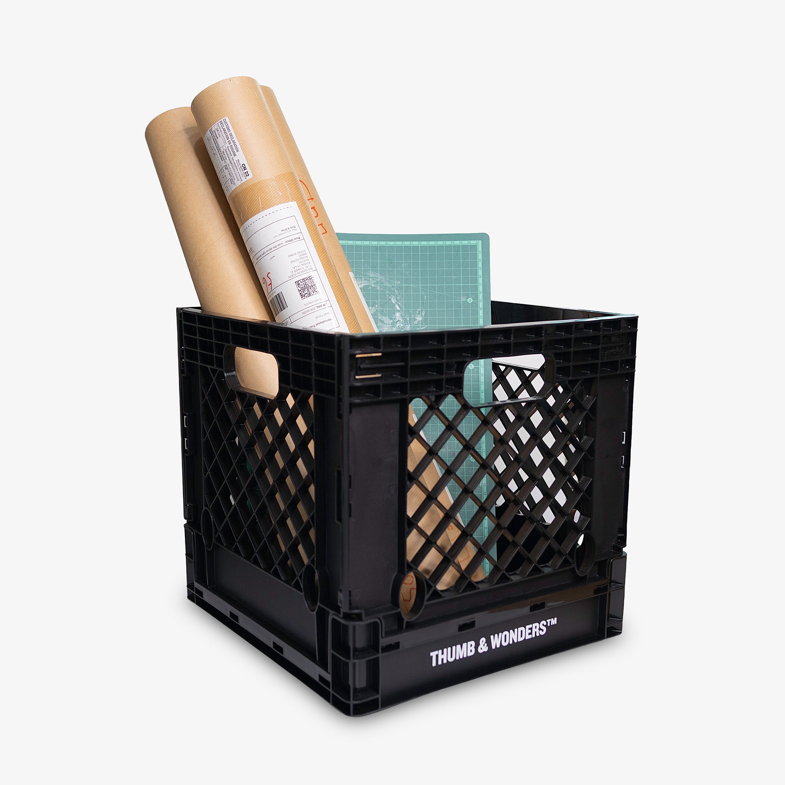 Black storage crate with office supplies on a white background, featuring the brand 'Thumb & Wonders'.
